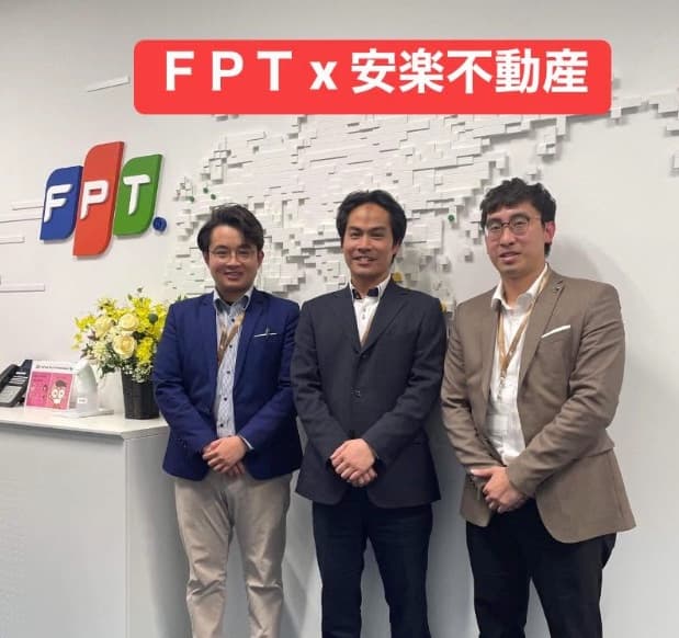 An Lac Real Estate members at an FPT office beneath an FPT × 安楽不動産 banner